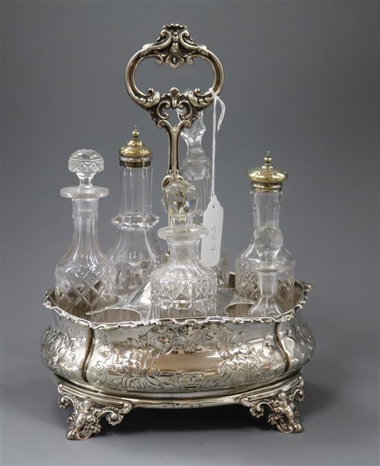 A Victorian embossed silver cruet stand, Roberts & Hall, Sheffield, 1853, with six later associated bottles, height 29.5cm.